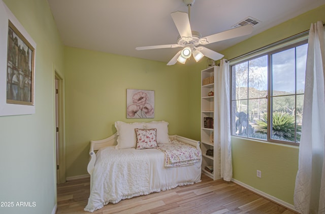 unfurnished bedroom with visible vents, wood finished floors, baseboards, and ceiling fan