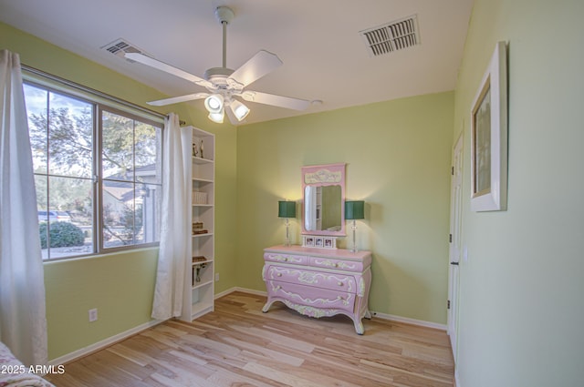 bedroom with light wood-type flooring, visible vents, baseboards, and ceiling fan