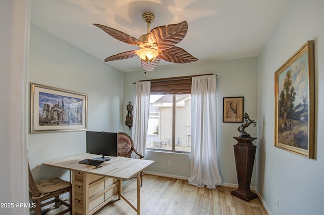 office featuring baseboards, light wood-style floors, and a ceiling fan