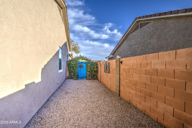 view of side of property featuring stucco siding and fence