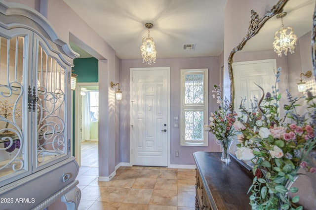 foyer entrance featuring a chandelier, visible vents, and a wealth of natural light