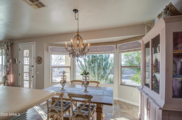 dining area featuring a notable chandelier, baseboards, and visible vents