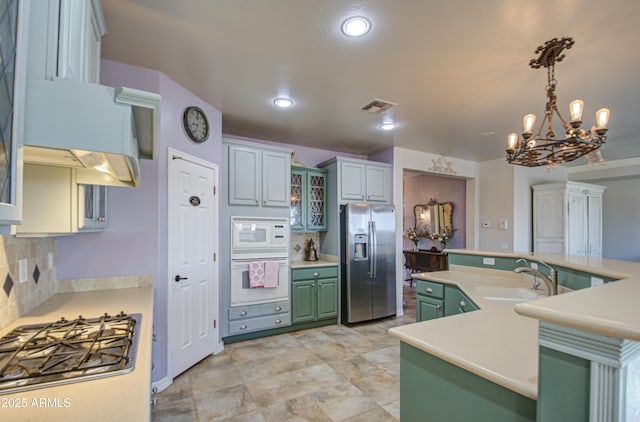 kitchen featuring visible vents, a sink, light countertops, appliances with stainless steel finishes, and green cabinetry