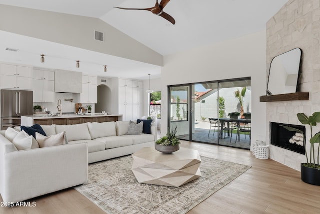14401 N 60th Pl, Scottsdale, AZ 85254 - living area featuring high vaulted ceiling, ceiling fan, a fireplace, and light wood finished floors