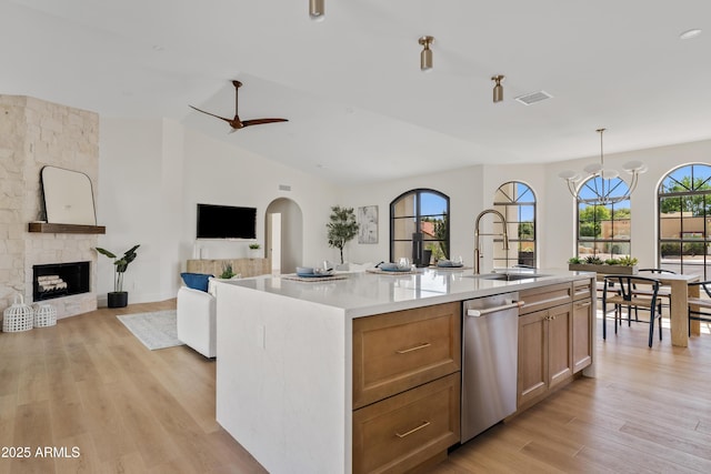 14401 N 60th Pl, Scottsdale, AZ 85254 - kitchen featuring stainless steel dishwasher, light countertops, a stone fireplace, light wood-style flooring, and open floor plan