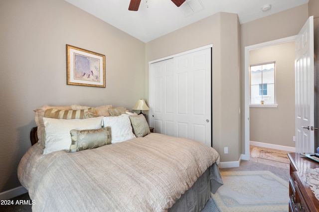 carpeted bedroom featuring ceiling fan and a closet