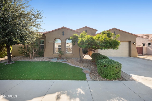 mediterranean / spanish house with a garage and a front yard