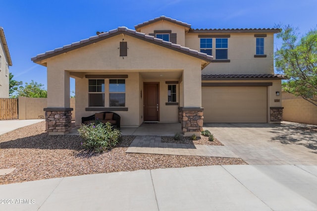 view of front of property featuring a tiled roof, driveway, fence, an attached garage, and stucco siding