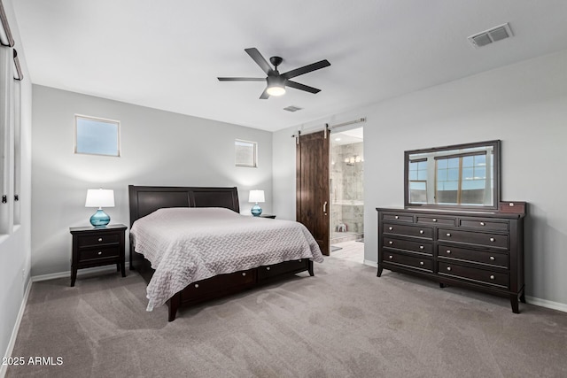 carpeted bedroom with a barn door, baseboards, ceiling fan, and connected bathroom
