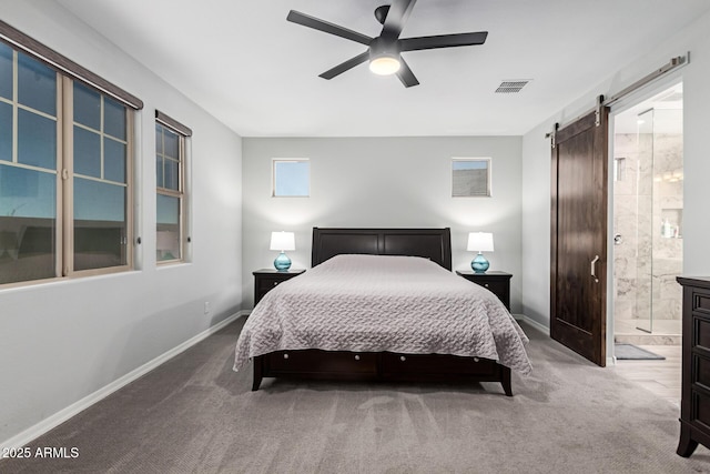 bedroom with a barn door, carpet floors, and baseboards