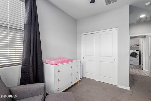 carpeted bedroom with washer / dryer, a closet, and a ceiling fan