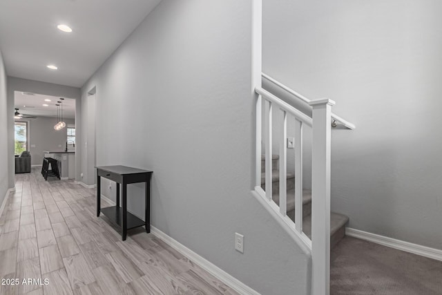 corridor with stairway, recessed lighting, baseboards, and light wood-type flooring