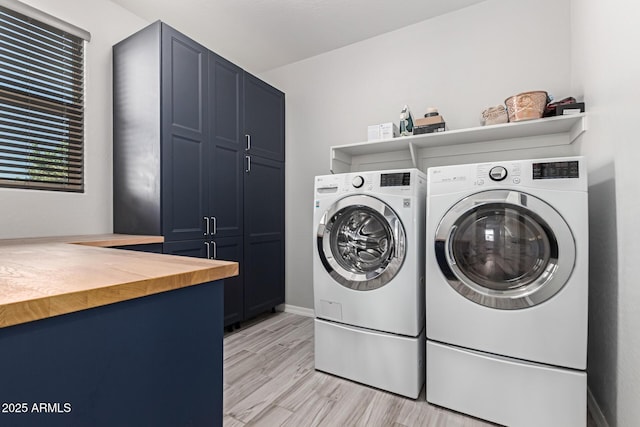laundry area with cabinet space, washing machine and clothes dryer, light wood-style floors, and baseboards