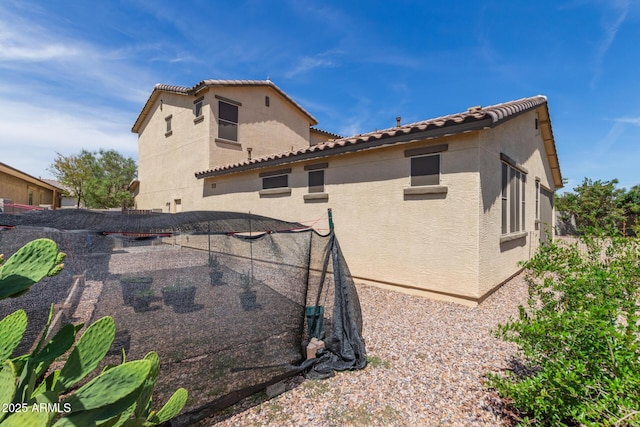 back of property featuring stucco siding and a tile roof