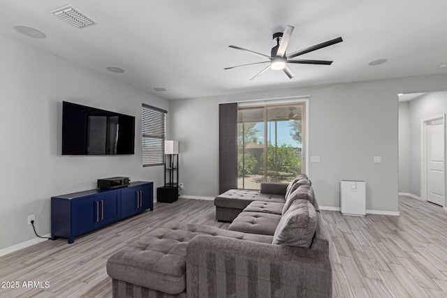 living room featuring light wood-type flooring, a ceiling fan, and baseboards