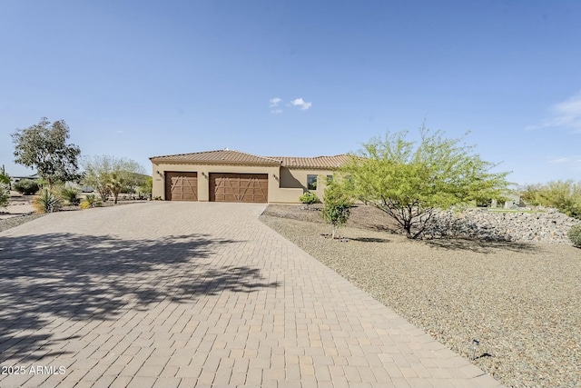 17324 E Quail Track Rd, Rio Verde, AZ 85263 - mediterranean / spanish-style home featuring a tiled roof, decorative driveway, stucco siding, and an attached garage