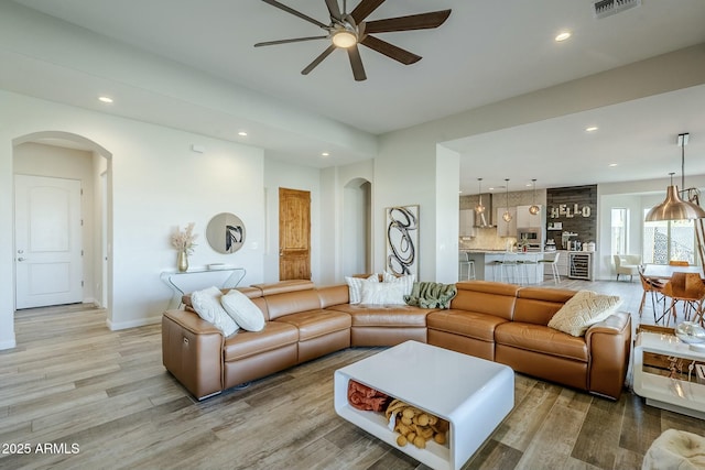 17324 E Quail Track Rd, Rio Verde, AZ 85263 - living room with arched walkways, visible vents, ceiling fan, and light wood-style flooring