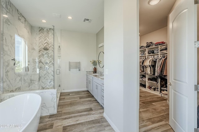17324 E Quail Track Rd, Rio Verde, AZ 85263 - bathroom with wood finished floors, a stall shower, a freestanding bath, and visible vents