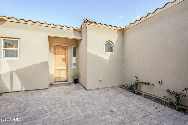 17324 E Quail Track Rd, Rio Verde, AZ 85263 - property entrance with stucco siding, a tiled roof, and a patio area