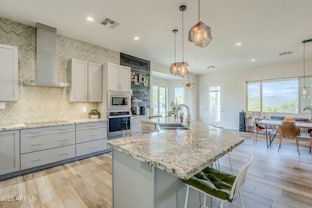 17324 E Quail Track Rd, Rio Verde, AZ 85263 - kitchen with a sink, visible vents, wall chimney range hood, and appliances with stainless steel finishes