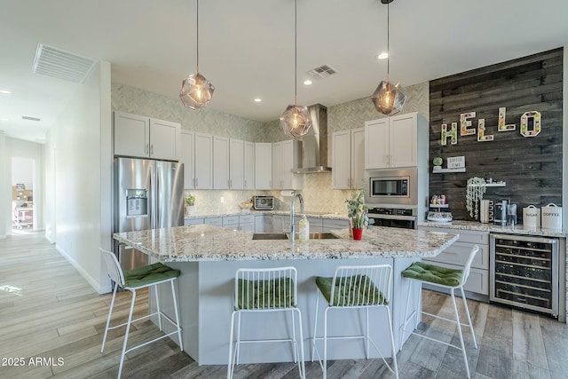 17324 E Quail Track Rd, Rio Verde, AZ 85263 - kitchen with wall chimney range hood, beverage cooler, visible vents, and stainless steel appliances