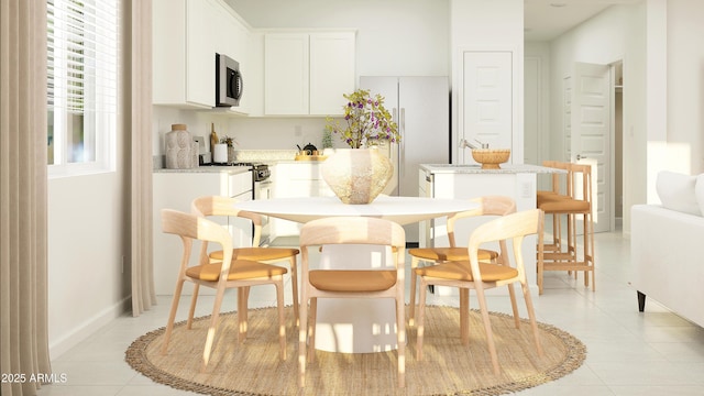 kitchen featuring range with gas cooktop, white cabinets, light countertops, stainless steel microwave, and a kitchen island