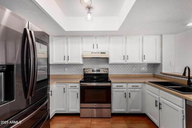 kitchen featuring light tile patterned floors, sink, appliances with stainless steel finishes, extractor fan, and white cabinets