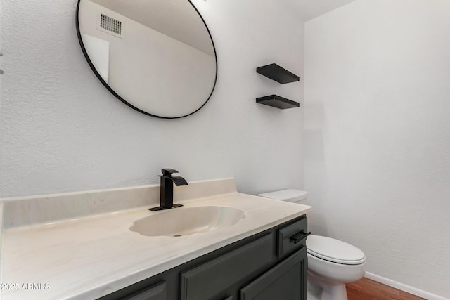 bathroom featuring hardwood / wood-style flooring, vanity, and toilet