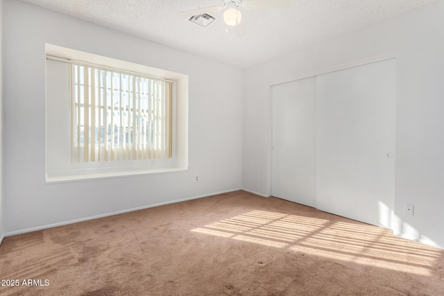 unfurnished room featuring ceiling fan, carpet, and a textured ceiling