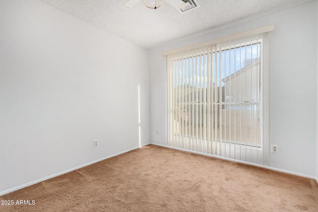 carpeted empty room with a textured ceiling