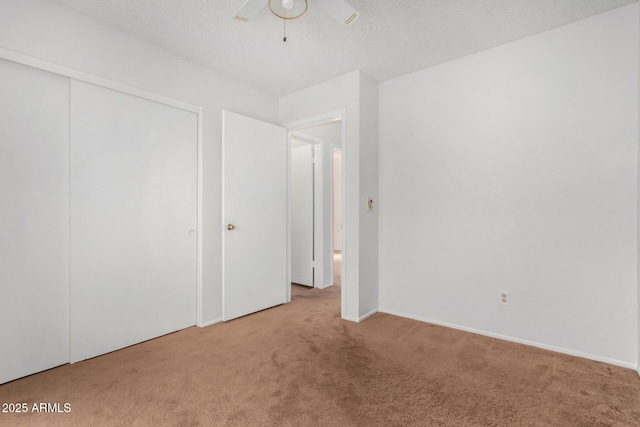 unfurnished bedroom with ceiling fan, a closet, and light carpet