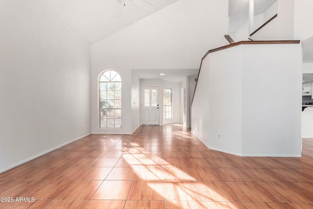 tiled foyer entrance featuring high vaulted ceiling