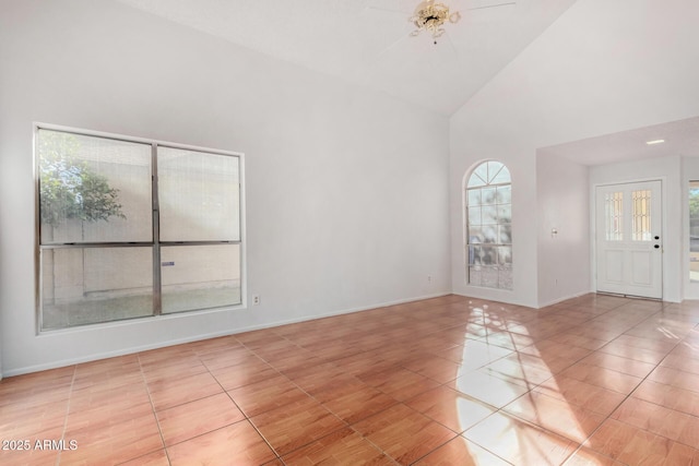 unfurnished room featuring high vaulted ceiling and light tile patterned flooring