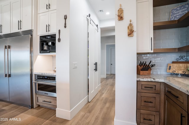 18125 W Montebello Ct Unit 67, Litchfield Park, AZ 85340 - kitchen featuring appliances with stainless steel finishes, open shelves, a barn door, light wood-style floors, and recessed lighting