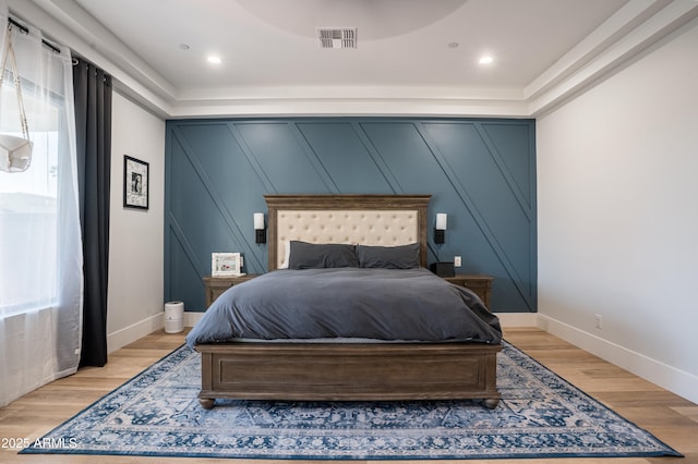 18125 W Montebello Ct Unit 67, Litchfield Park, AZ 85340 - bedroom featuring a decorative wall, light wood-style flooring, multiple windows, and baseboards