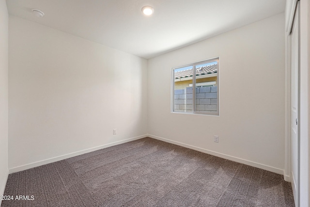 empty room featuring dark colored carpet