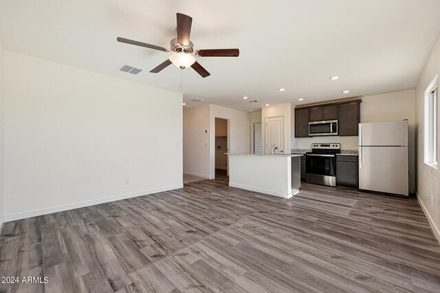 unfurnished living room featuring sink, wood-type flooring, and ceiling fan