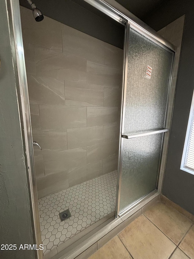 bathroom featuring tile patterned flooring and a shower with shower door