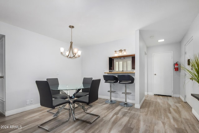 dining space featuring a notable chandelier and light hardwood / wood-style flooring