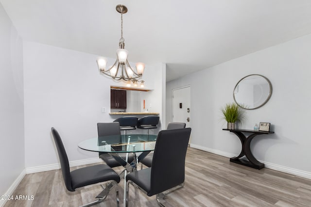 dining area featuring an inviting chandelier and hardwood / wood-style floors