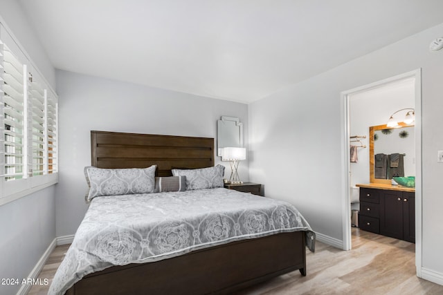 bedroom featuring ensuite bath and light hardwood / wood-style flooring