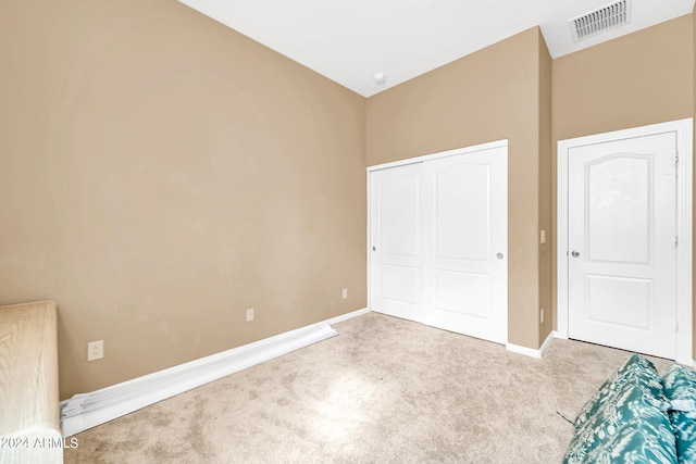 unfurnished bedroom featuring carpet, a closet, visible vents, and baseboards