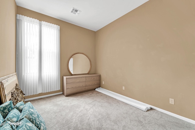 unfurnished bedroom with carpet flooring, visible vents, and baseboards