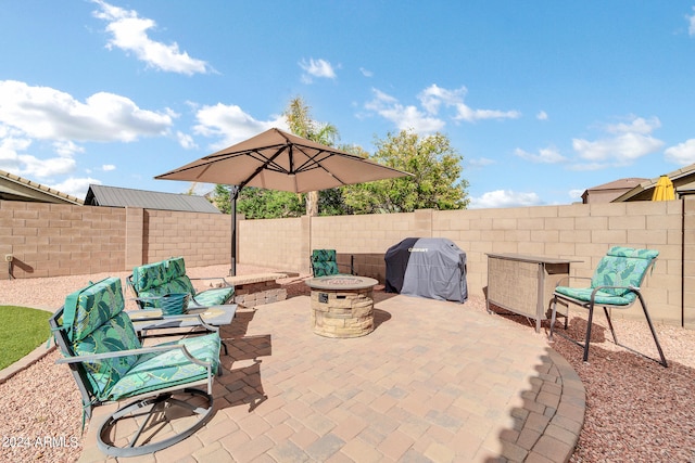 view of patio with an outdoor fire pit, a fenced backyard, and a grill