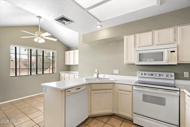 kitchen featuring sink, vaulted ceiling, kitchen peninsula, white appliances, and white cabinets