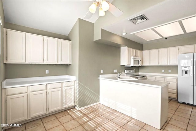 kitchen with sink, white cabinets, light tile patterned floors, kitchen peninsula, and white appliances