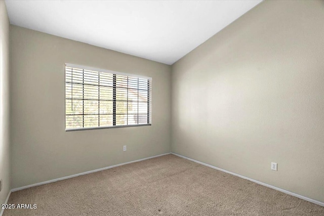 carpeted empty room with vaulted ceiling