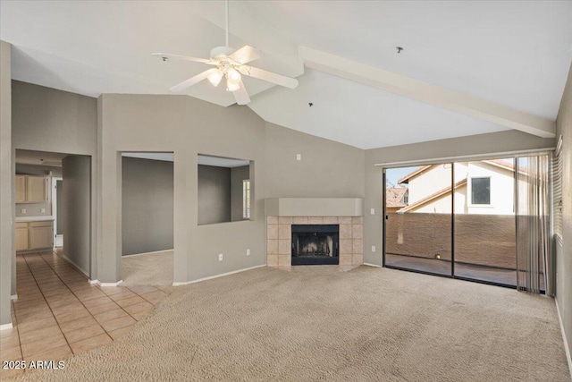 unfurnished living room featuring a tile fireplace, high vaulted ceiling, beamed ceiling, ceiling fan, and light carpet