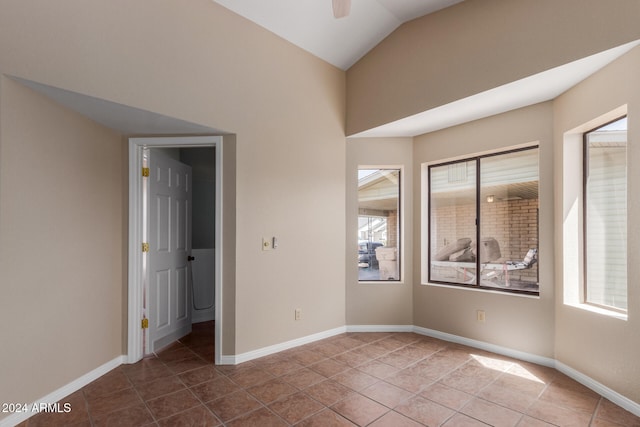 tiled empty room featuring ceiling fan and vaulted ceiling