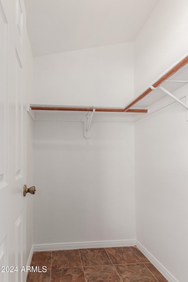 spacious closet featuring dark tile patterned floors